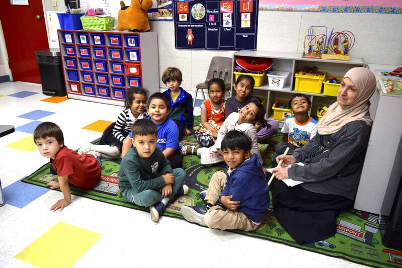 A teacher supporting students at a weekend Islamic school